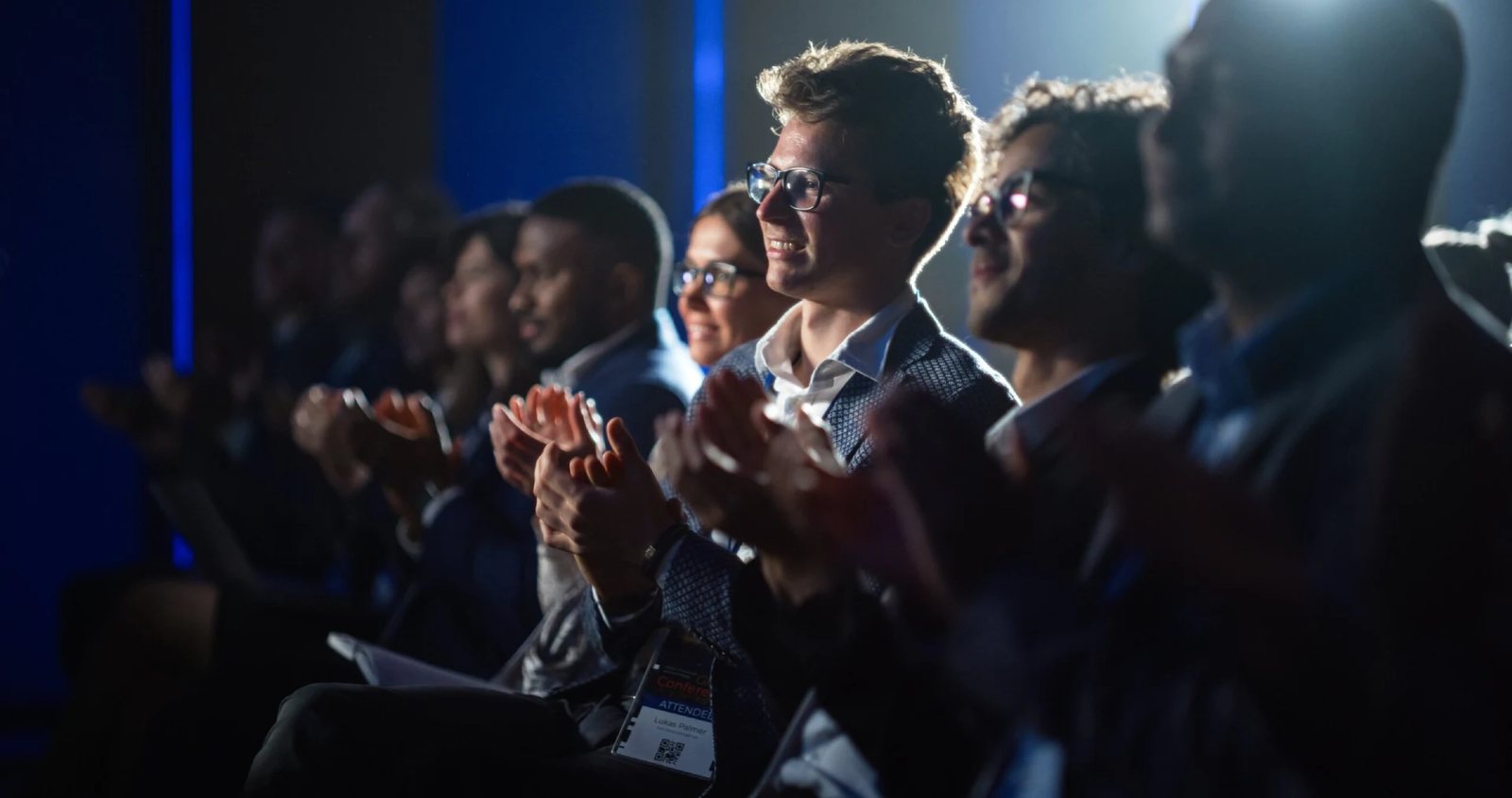 An engaged audience applauding at a conference